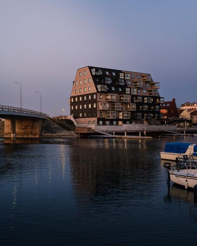 Buildings by the river at sunset